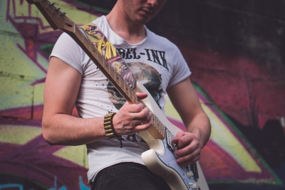 Homme tenant une guitare électrique