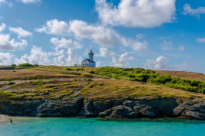 Phare blanc sur une falaise rocheuse au bord de la mer