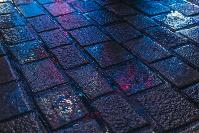 Pavés sombres mouillés avec reflets bleus