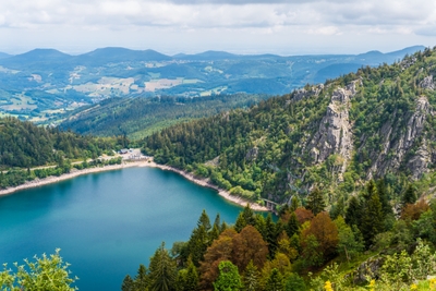 Lac de montagne entouré de forêts et de reliefs
