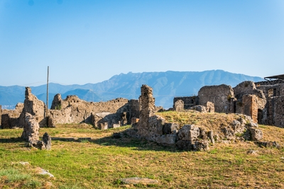 Ruines de Pompeï dans une prairie avec montagnes en arrière-plan