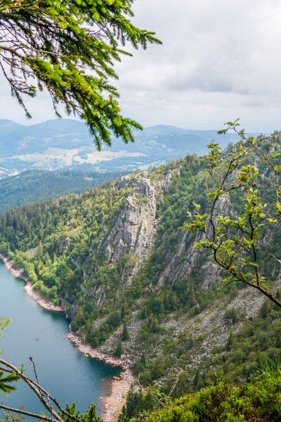Lac au pied de falaises rocheuses et de forêt dense