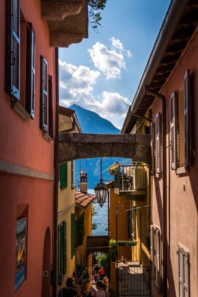 Ruelle étroite entre façades colorées avec arche en pierre
